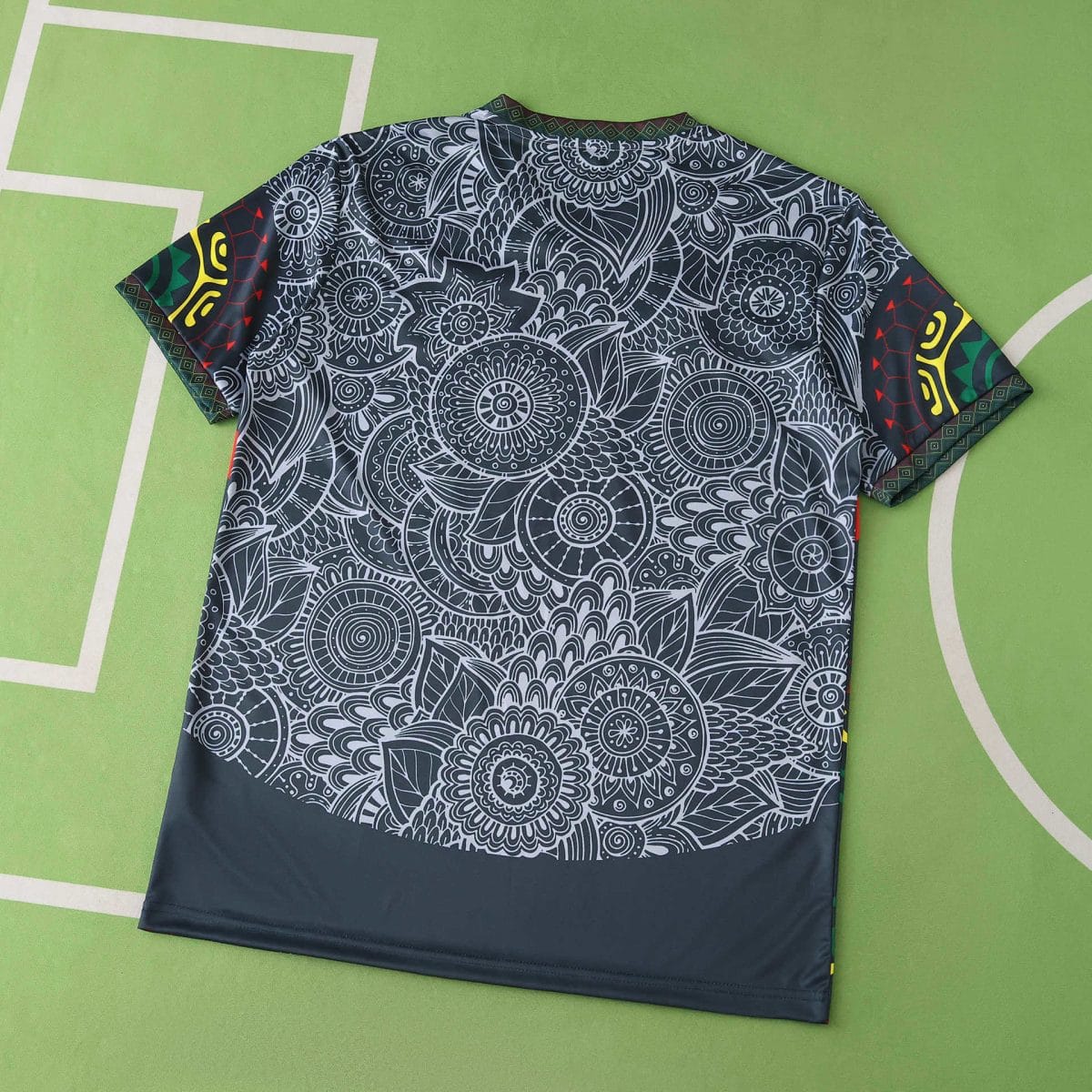 Dark fabric with dense white mandala floral pattern spread on a green background.