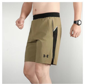 Man wearing tan athletic shorts with a black waistband and a visible zip pocket on the side, Under Armour logo on the leg.