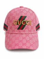 Pink Gucci baseball cap with repeating GG pattern and gold Gucci lettering, green-red-green stripes along sides.