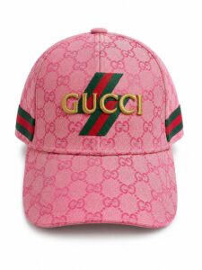 Pink Gucci baseball cap with a repeating GG monogram, a green-red stripe motif, and gold Gucci lettering on the front.