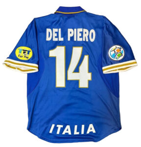 Blue Italy national team football jersey viewed from the back, showing the name 'DEL PIERO' and large number 14, with 'ITALIA' at the hem and patches on both sleeves (Fair Play on left, colorful emblem on right).