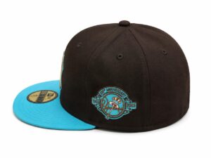 Black cap with a bright turquoise brim and a turquoise circular anniversary emblem on the side.