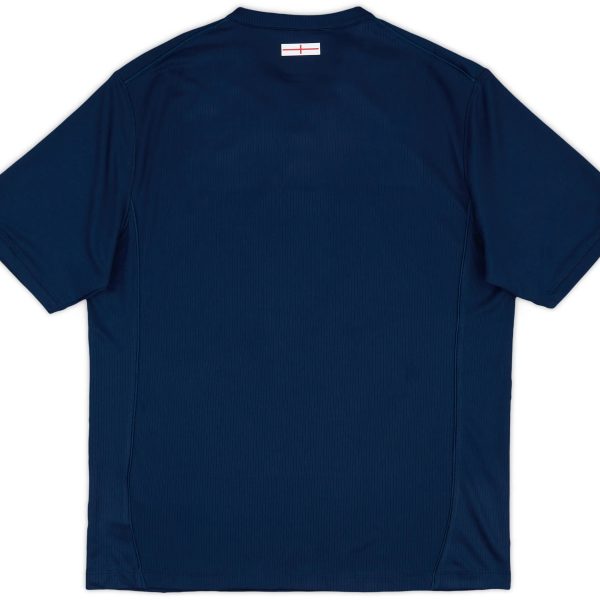 Back view of a navy blue polo shirt with a small white label featuring a red line near the collar area