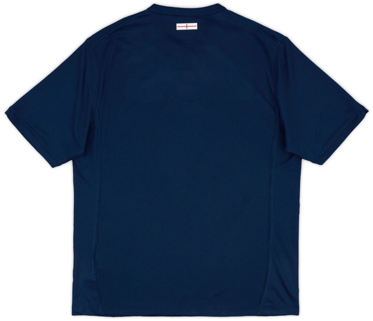 Back view of a navy blue polo shirt with a small white label featuring a red line near the collar area