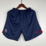 80e4d7dd_2f1504f2-f8bb-4a72-9fb2-192f293eae1f | UAE SPORT STORE Navy athletic shorts on a hanger with PSG badge on the left leg and a red Nike swoosh on the right leg.