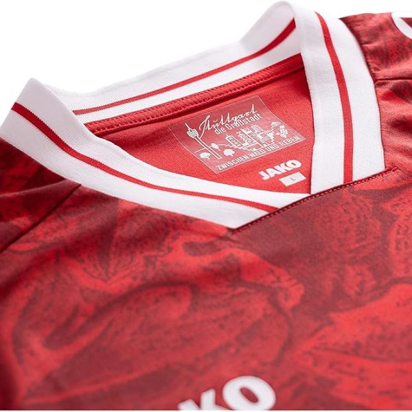 Close-up of a red sports jersey neckline with a white striped collar and the JAKO brand label visible on the collar interior.