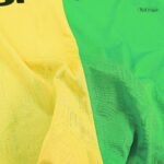 Close-up of yellow and green fabric with a subtle embossed pattern and folds.
