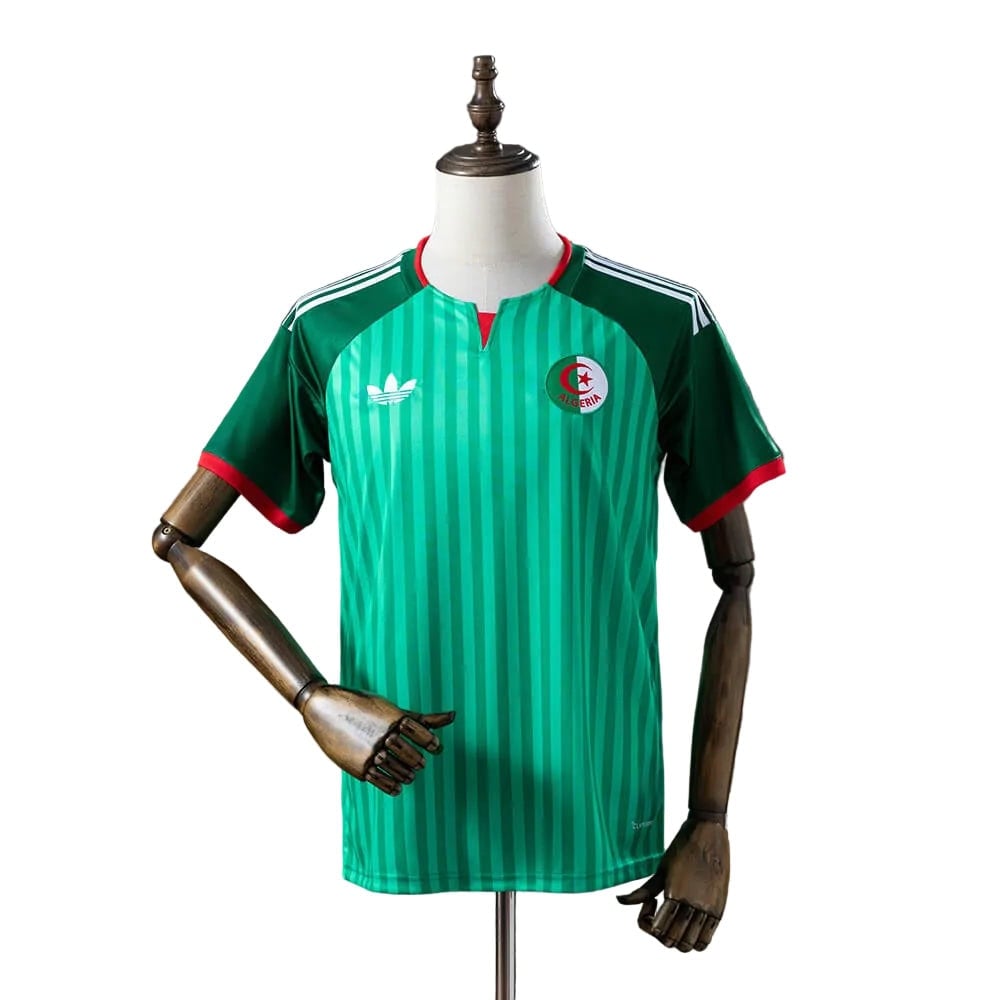 81b9a98a | UAE SPORT STORE Front view of a green Algeria national team soccer jersey on a mannequin, featuring vertical stripes and crest.