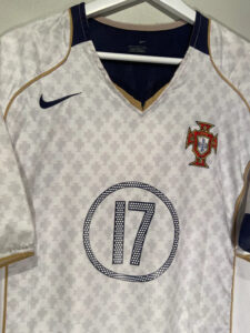 Portugal national team soccer jersey with number 17, white with navy and gold trim, crest on chest.