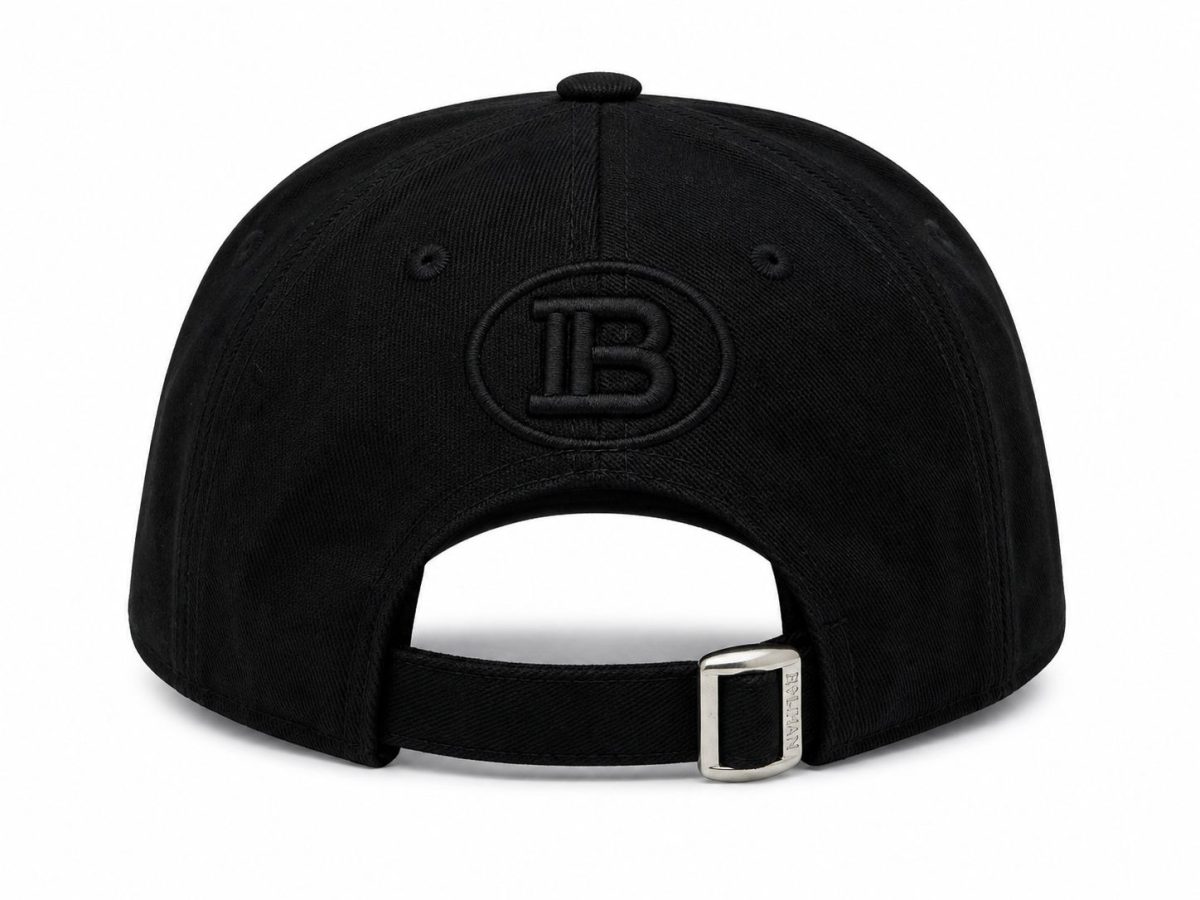 Back view of a black baseball cap with an adjustable strap and silver buckle; embroidered circular 'IB' logo on the back panel.