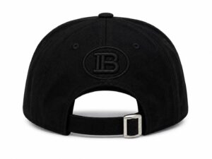 Back view of a black baseball cap with an adjustable strap and silver buckle; embroidered circular 'IB' logo on the back panel.