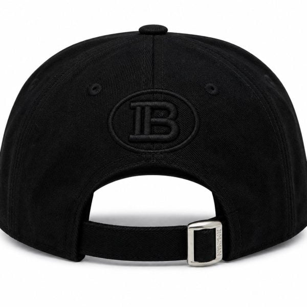 Back view of a black baseball cap with an adjustable strap and silver buckle; embroidered circular 'IB' logo on the back panel.