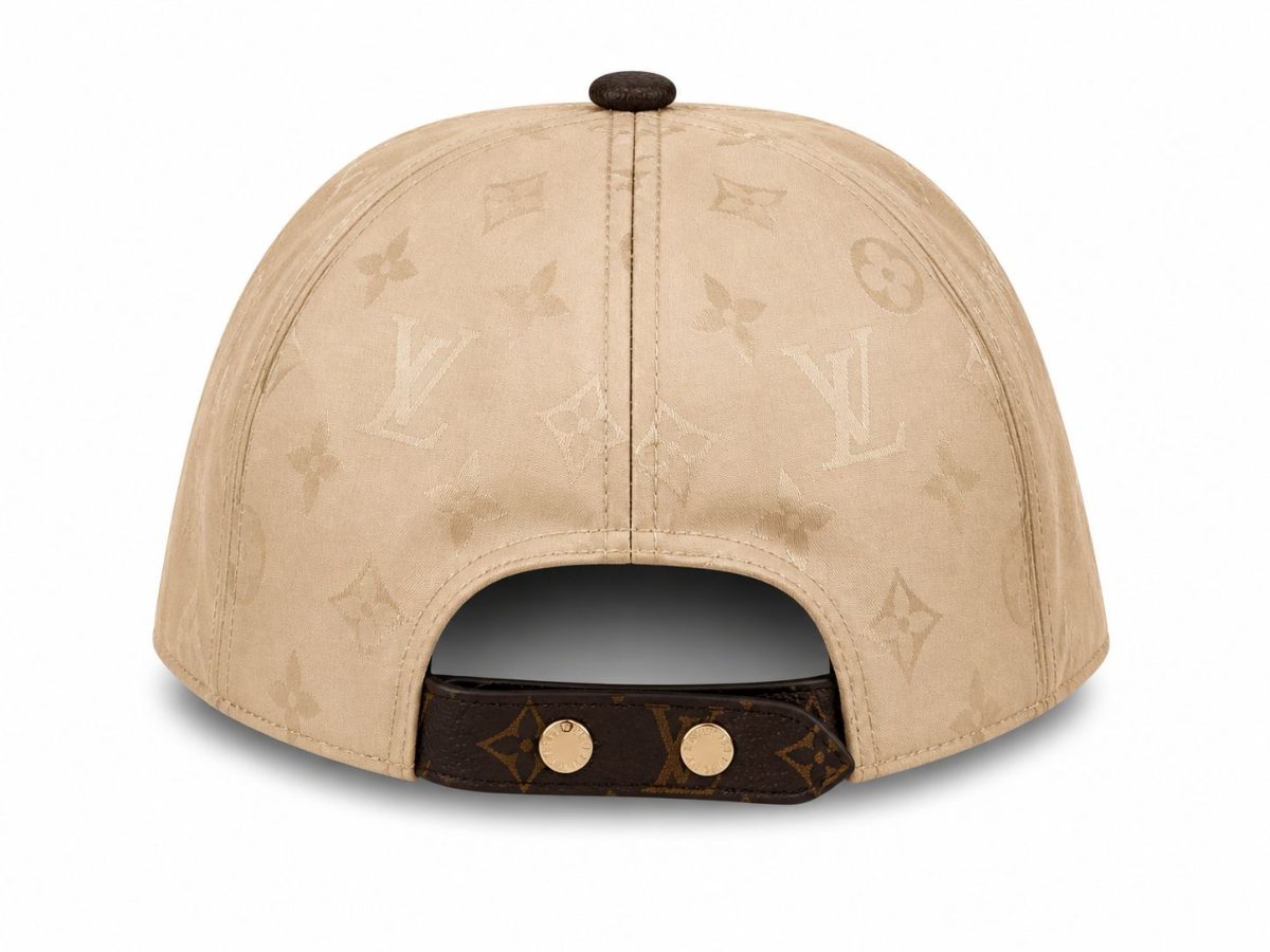 Back view of a beige Louis Vuitton cap with an adjustable strap and gold-tone studs, showing the LV monogram pattern.