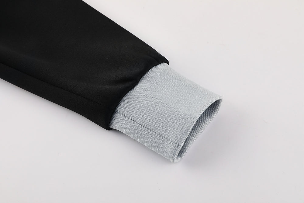 858d1a66 | UAE SPORT STORE Close-up of a black jacket sleeve ending in a light gray ribbed cuff