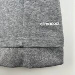 864371c9_57d2abed-227d-4977-9c05-cb788d9b7978 | UAE SPORT STORE Close-up of heather gray knit fabric with a vertical seam and a partial 'climacool' logo at the edge.