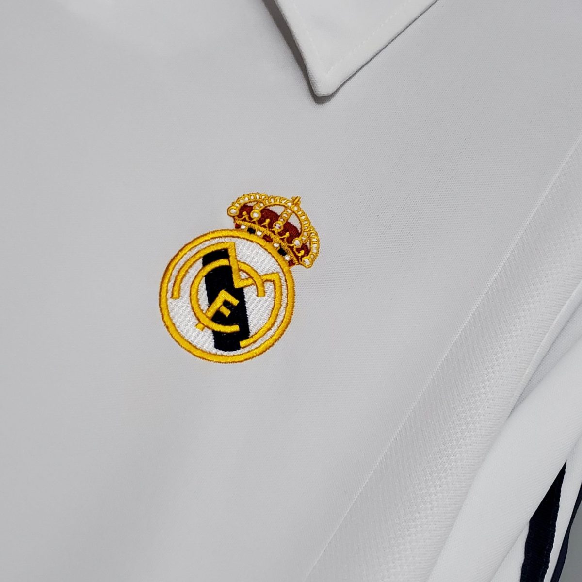 Partial Real Madrid crest embroidered on white fabric.
