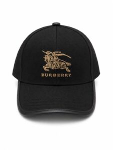 Black Burberry baseball cap with gold embroidered knight on horseback and BURBERRY text on front panel.
