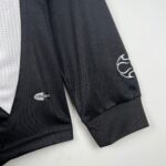 87d4275e_cbf295e7-9cb8-4d71-aeb8-30da68fd97a9 | UAE SPORT STORE Close-up of black athletic fabric with a white embroidered design and a CLIMACOOL badge visible on the left.