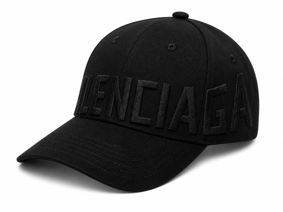 Black baseball cap with large black-on-black embroidered text across the front, curved brim, solid color. The front features oversized raised lettering running along the crown edge.