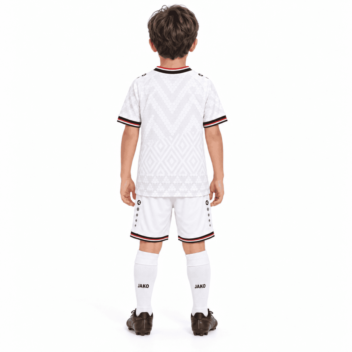 Child in Iraq home kids football kit, white with black and red accents.