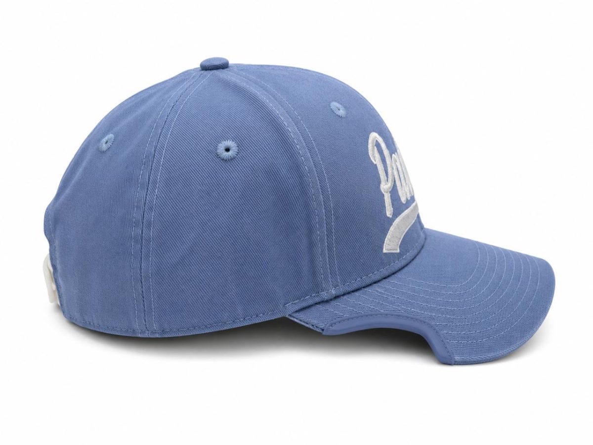 Blue baseball cap with a curved brim and white embroidered text on the front, photographed from the side/tilted angle.