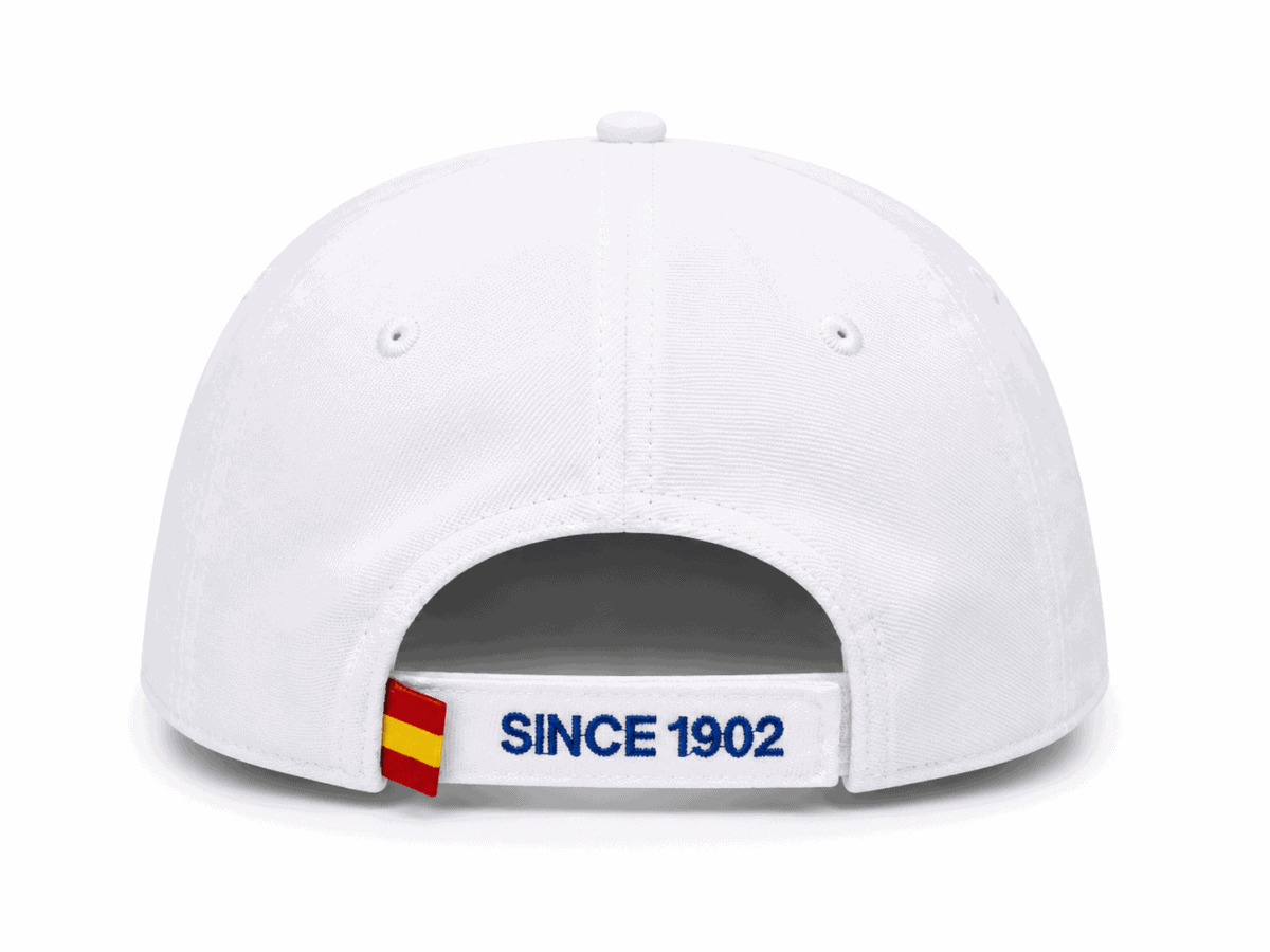 Back view of a white baseball cap with an adjustable strap reading 'SINCE 1902' and a small red-yellow tag on the side.