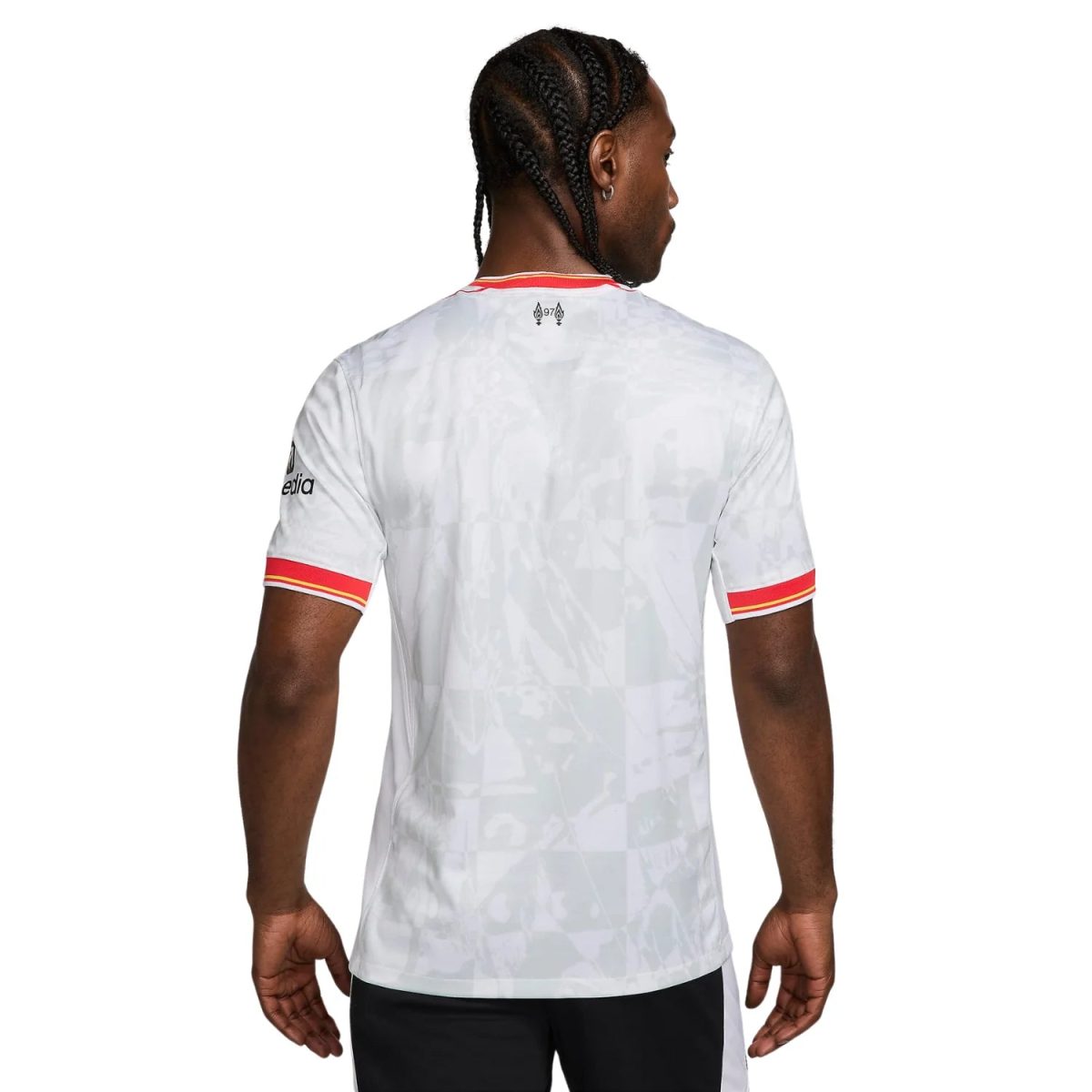 Back view of a white sports jersey with red and yellow striped sleeve cuffs and a small logo near the neckline, worn by a man with braided hair.