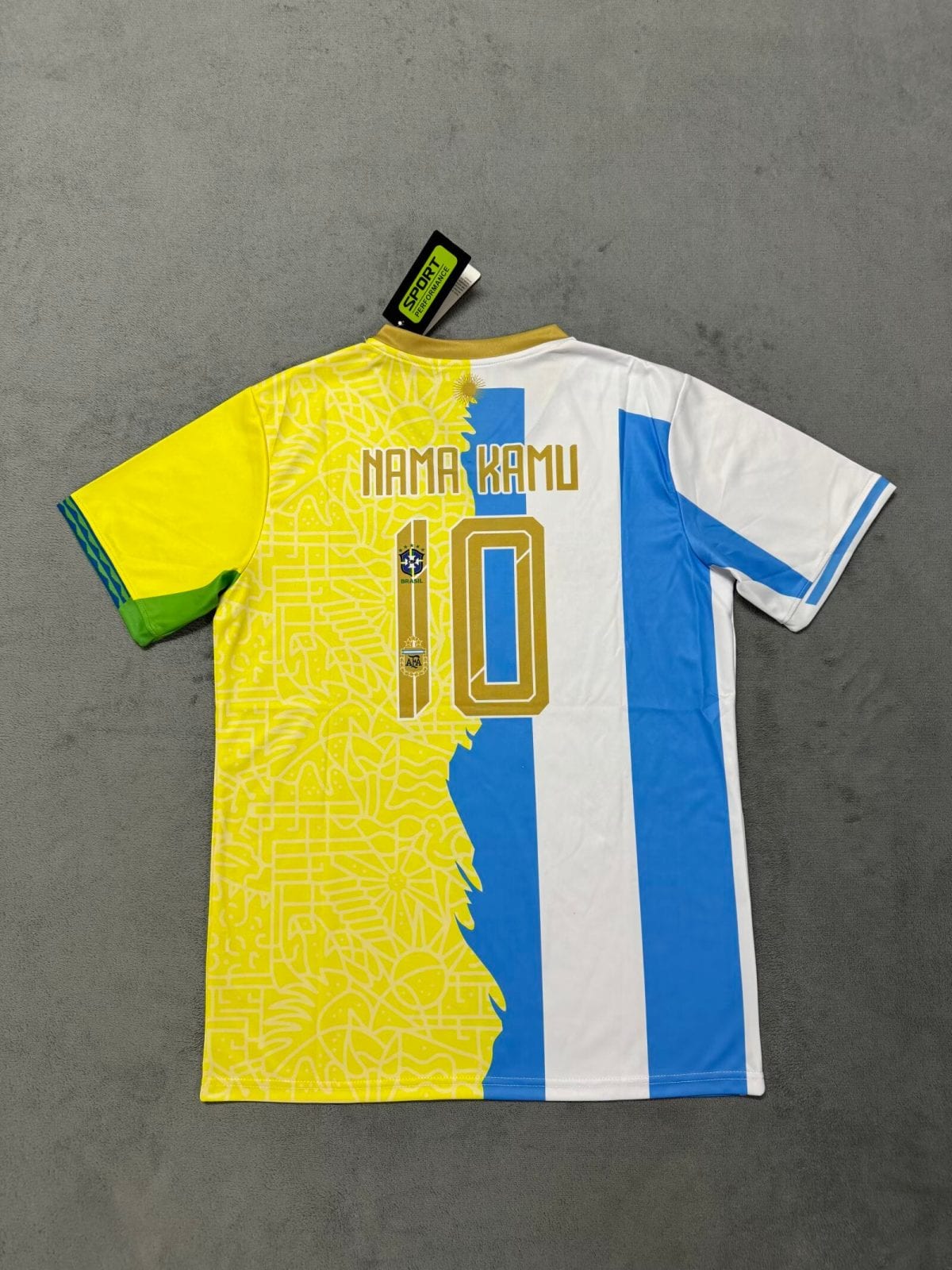 Colorful soccer jersey laid flat with yellow patterned left panel, blue vertical stripe, and the number 10; tag reads SPORT PERFORMANCE near the collar edge.