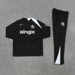 Black Chelsea FC training kit laid flat: long-sleeve top with Bingx sponsor, Nike swoosh, and white panel, plus matching black pants with club crest.