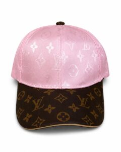 Pink satin cap with white Louis Vuitton monogram on crown and a brown LV-patterned brim.