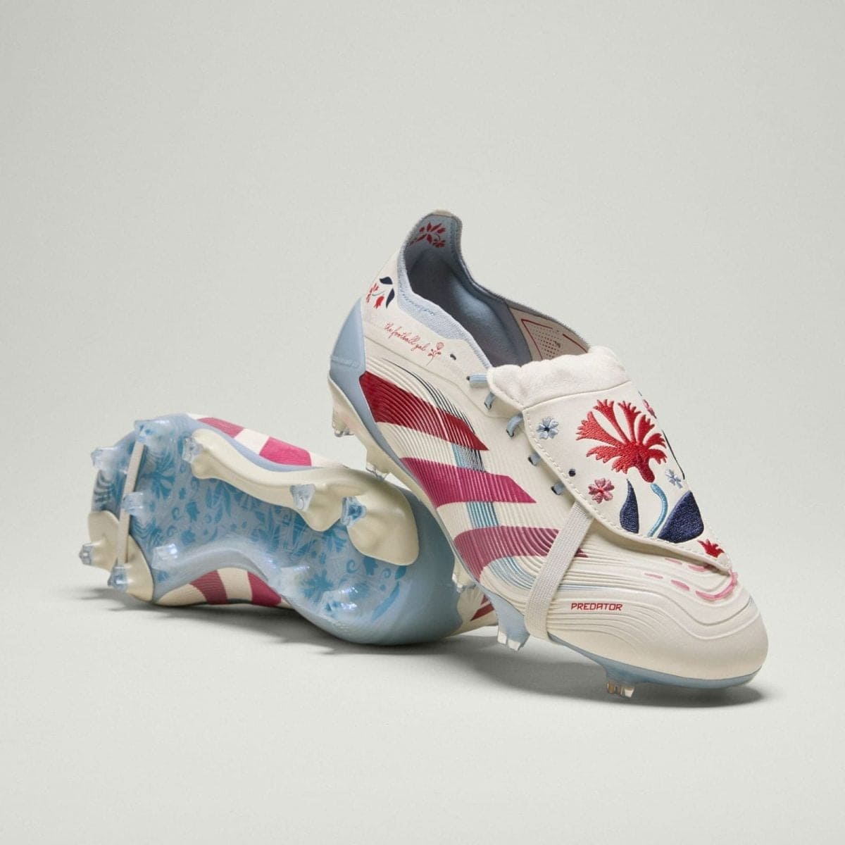 White athletic sneaker with red-blue floral embroidery and a pale blue sole on a neutral background.
