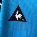 Close-up of bright blue textured fabric with a black triangular patch featuring a white curved design.