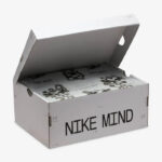 White Nike Mind shoebox with lid open, tissue paper inside and bold 'NIKE MIND' lettering on the side