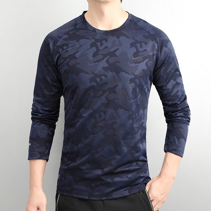 8c53cb60 | UAE SPORT STORE Man wearing a navy blue camouflage-pattern long-sleeve athletic shirt with a small Nike swoosh on the chest.