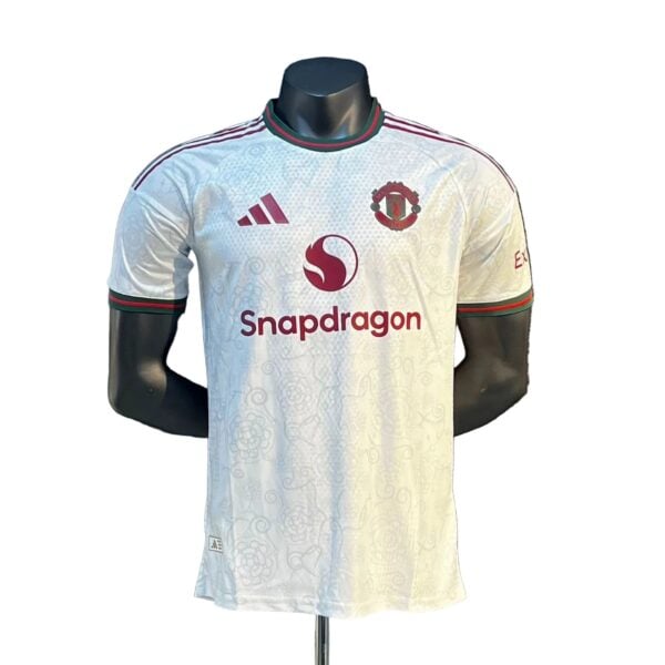 White Manchester United football jersey with Snapdragon sponsor and club crest on the chest.