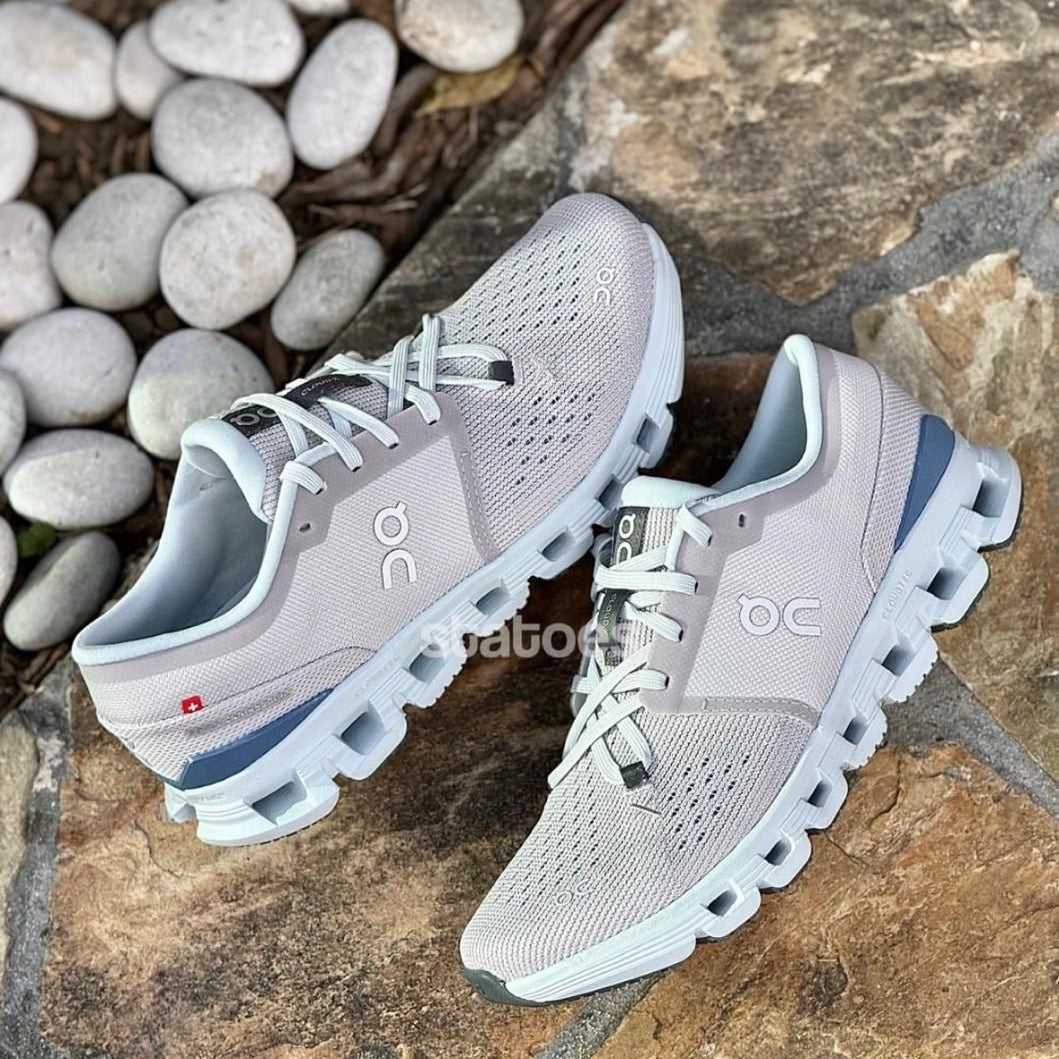 8c8d4142-8c7e-4b78-adc4-0a137c36149c | UAE SPORT STORE Pair of light gray On running shoes with perforated uppers and cloud-like midsole on a stone surface.