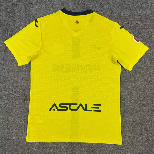 Bright yellow athletic jersey laid flat on a gray carpet, with a dark collar and the 'ASTALE' sponsor logo across the front.