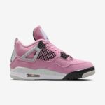 Pink suede sneaker with grey cage accents, black mesh panels, and a speckled white midsole featuring a visible air unit.