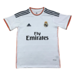 White Real Madrid football jersey with Fly Emirates sponsor, Real Madrid crest, and Adidas stripes on shoulders.