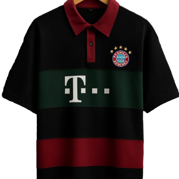 Black polo shirt on a wooden hanger with a red collar and green chest stripe, displaying a Bayern Munich crest and a Telekom logo.