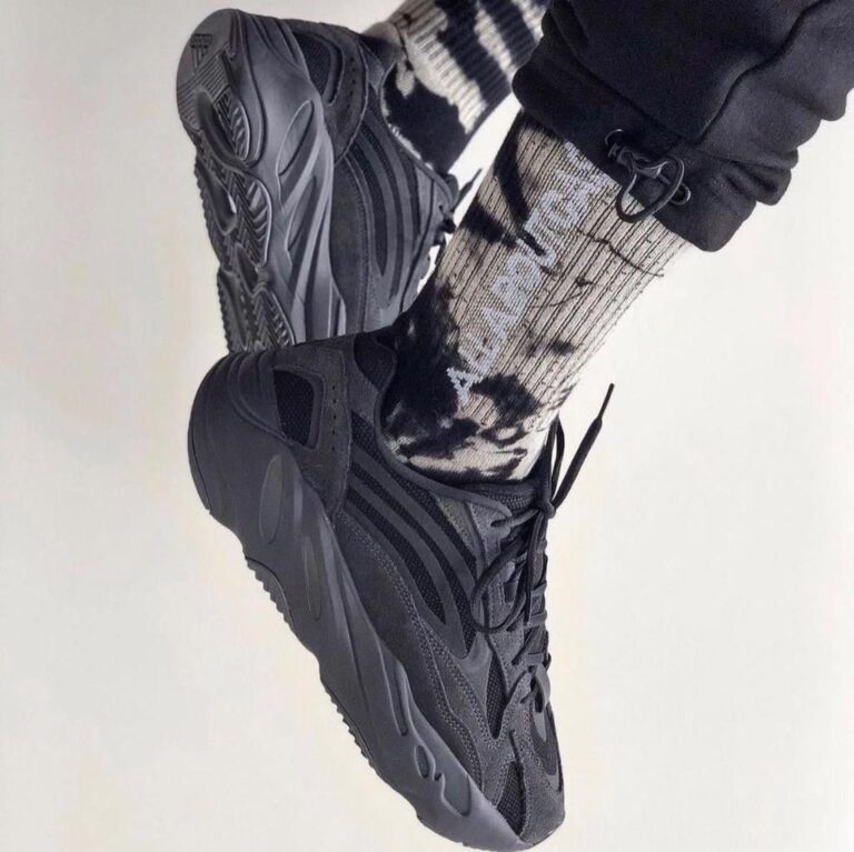 Dark gray chunky sneakers worn with a black-and-white patterned sock, shown in a tilted photo venue