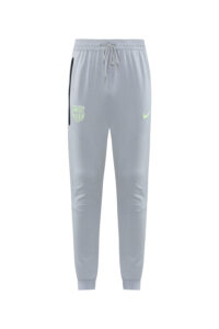 Light gray joggers with a drawstring waist, neon Barcelona crest on the left thigh, neon Nike swoosh on the right, and a black zip pocket on the left