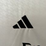 Close-up of a light gray knit fabric with a bold black diagonal stripe/pattern at the bottom edge.