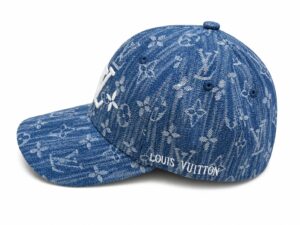 Blue denim baseball cap with white floral pattern and Louis Vuitton lettering on the side.