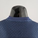 Back of a glossy black mannequin head wearing a blue denim jacket, viewed from above.