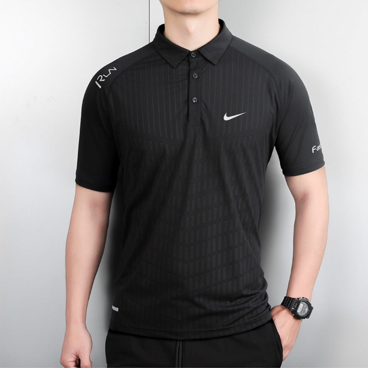 A man wearing a black polo with a subtle vertical stripe pattern and a white Nike swoosh on the chest.