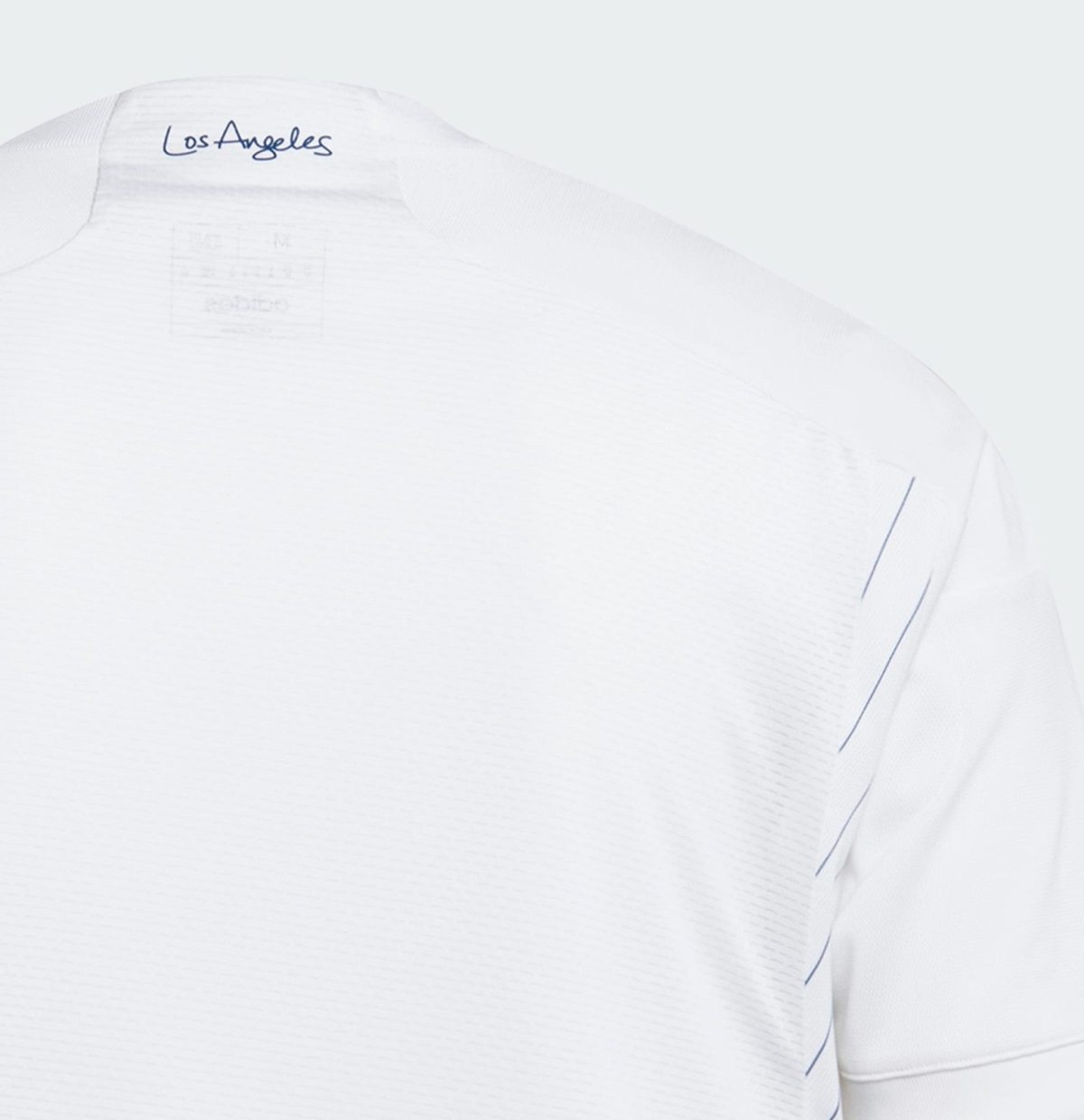 Close-up of a white shirt shoulder with blue 'Los Angeles' script on the collar edge.