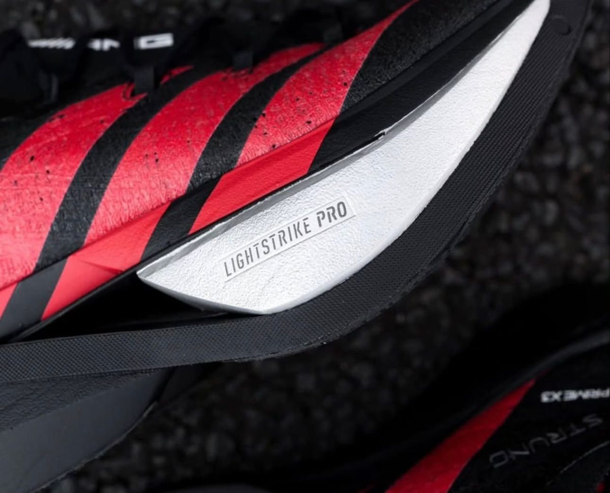 Close-up of a red and black running shoe showing the 'Lightstrike Pro' badge on the white midsole.