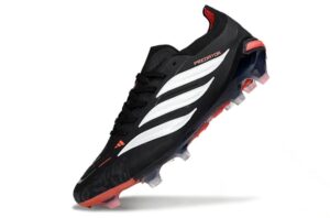 91198e95-8de0-4300-a16d-6e57f31d6c58 | UAE SPORT STORE Black soccer cleat with white stripes and red accents, angled to showcase the studded sole on a white background.