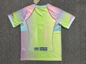 Back view of a bright multi‑color athletic jersey with neon yellow, pink, blue and purple panels and pink piping, featuring UNHCR logo at the lower back.